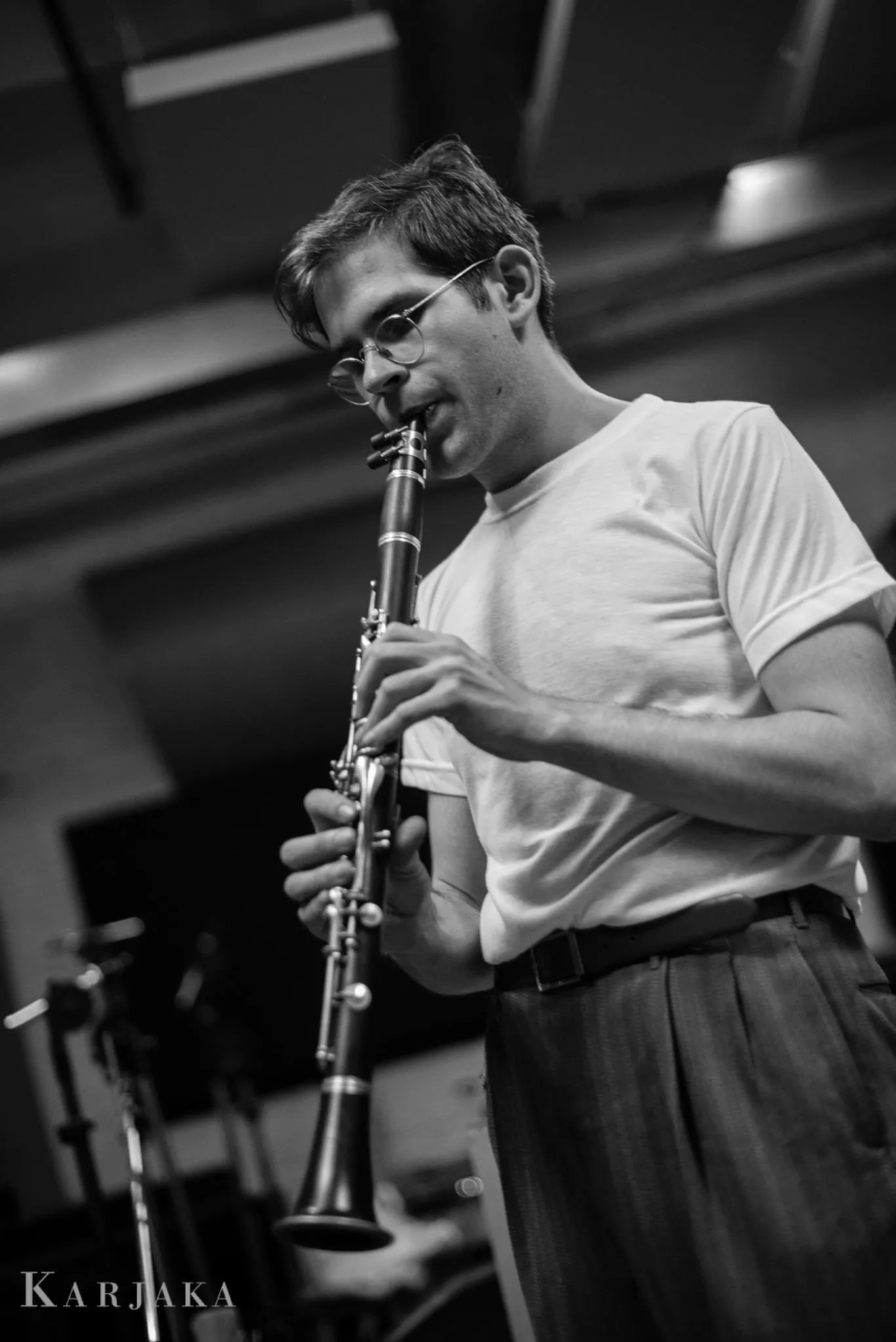 Black and white photograph of a young Aaron Johnson playing clarinet in a white T-shirt.